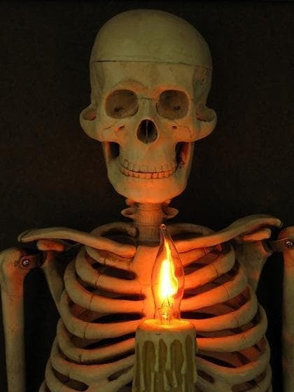 Inramad skelettöverkropp som väggdekoration för Halloween med ljusformad glödlampa