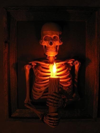Inramad skelettöverkropp som väggdekoration för Halloween med ljusformad glödlampa